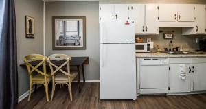 a kitchen with a white refrigerator and a table and chairs at Eclectic Abode in Cleveland