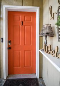 eine orangefarbene Tür eines Hauses mit einer Lampe in der Unterkunft Eclectic Abode in Cleveland