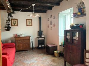 的住宿－Casa nel borgo - A Rigadèa，客厅配有红色沙发和燃木炉。