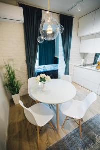 a dining room with a white table and chairs at Atlant luxury Status Apart on Golovna навпроти ТЦ ДЕПОТ БЕЗКОНТАКТНЕ ЗАСЕЛЕННЯ in Chernivtsi