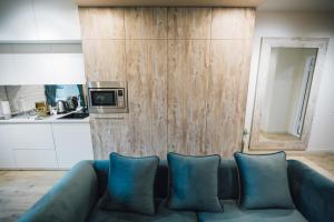 ein Wohnzimmer mit einer blauen Couch in einer Küche in der Unterkunft Atlant luxury Status Apart on Golovna навпроти ТЦ ДЕПОТ БЕЗКОНТАКТНЕ ЗАСЕЛЕННЯ in Czernowitz