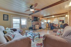 uma sala de estar com 2 sofás e uma ventoinha de tecto em Cozy Houghton Lake Vacation Rental with Fireplace! em Houghton Lake