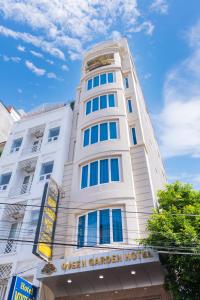 a tall white building with a sign on it at Queen Garden Hotel & Apartment in Vung Tau