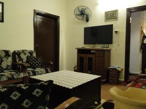 a living room with a table and a tv at ( b&b ) Gadara rent room in Um Qeis