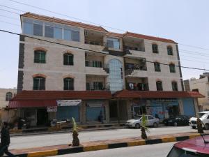a building on a street with cars parked in front of it at ( b&b ) Gadara rent room in Um Qeis