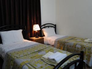 a hotel room with two beds and a table with a lamp at ( b&b ) Gadara rent room in Um Qeis