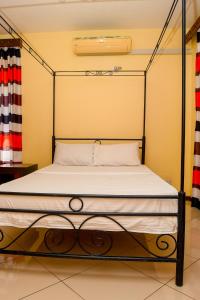 1 dormitorio con 1 cama con marco de metal en Taste of Mexico Hostel, en Dar es Salaam