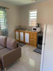 uma sala de estar com um sofá e uma cozinha com um frigorífico em Miki Miki Surf Lodge em Moorea