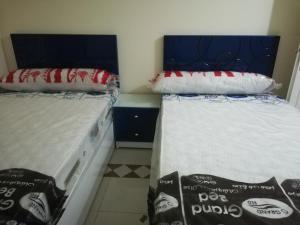 duas camas sentadas uma ao lado da outra num quarto em شقة فاخرة بالغردقة em Hurghada