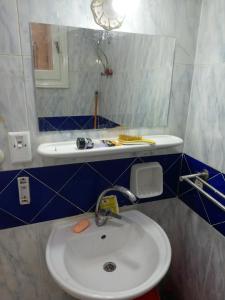 uma casa de banho com um lavatório branco e um espelho. em شقة فاخرة بالغردقة em Hurghada