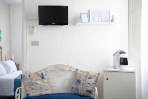 ein Schlafzimmer mit einem Stuhl und einem Fernseher an der Wand in der Unterkunft Antonia Jess Central ,Near Beach- by Gessica homes in Monopoli