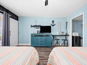 a bedroom with two beds and a desk with a tv at Lr 119 - Simpatico in Rockport