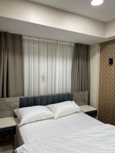 1 dormitorio con 1 cama grande con sábanas blancas en FLORYA EXPRESS OTEL, en Estambul