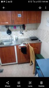 eine Küche mit Holzschränken, einer Spüle und einem Tisch in der Unterkunft Matinxs Home in Abu Dhabi