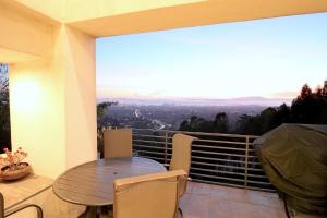 een tafel en stoelen op een balkon met uitzicht bij Luxurious Hillside Home Wac & Gorgeous Sf Views! in Oakland