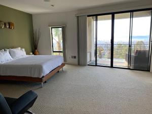 een slaapkamer met een bed en een grote glazen schuifdeur bij Luxurious Hillside Home Wac & Gorgeous Sf Views! in Oakland