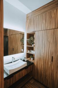 a bathroom with a white sink and wooden walls at Oasis 444 in San Marcos