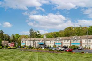 a large building with cars parked in a parking lot at Best Western Plus New England Inn & Suites in Berlin