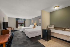 a hotel room with two beds and a television at SureStay Plus Hotel by Best Western Berkeley Springs in Berkeley Springs