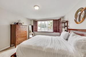 舊金山的住宿－外部日落之家度假屋，卧室设有一张白色大床和一扇窗户。