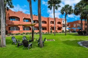 a resort with palm trees in front of a building at SureStay Plus Hotel by Best Western The Villages in Lady Lake