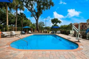 a swimming pool with blue water in a brick patio at SureStay Plus Hotel by Best Western The Villages in Lady Lake