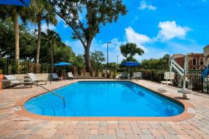 uma piscina com água azul num pátio de tijolos em SureStay Plus Hotel by Best Western The Villages em Lady Lake