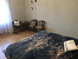 - une chambre avec un lit doté d'une couverture bleue et de chaises dans l'établissement Casa Sautrana, à Bielmonte