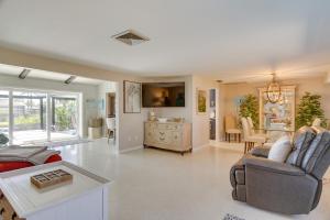 sala de estar con sofá y mesa en Canalfront Home with Dock and Pool 5 Mi to Ft Myers!, en North Fort Myers