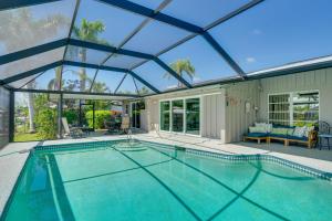 an indoor swimming pool in a house with a glass roof at Canalfront Home with Dock and Pool 5 Mi to Ft Myers! in North Fort Myers