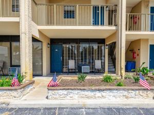 an apartment building with two american flags in a courtyard at Laguna Reef #119 - Simpatico in Rockport