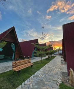 un banc en bois dans un parc avec un bâtiment dans l'établissement Pousada Al Mare Beach, à Luis Correia