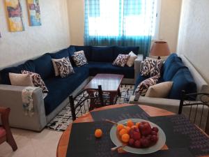 ein Wohnzimmer mit einem blauen Sofa und einem Tisch in der Unterkunft SolMar 1 in Martil