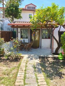 a small house with a patio and a tree at CasaMoltoCarina Cottage Garden in Minturno