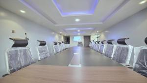 una sala de conferencias vacía con una mesa larga y sillas en Ikeja Airport View, en Lagos