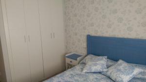 a bedroom with a blue bed and a white cabinet at APARTAMENTO GIJON - LA ARENA in Gijón