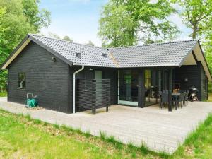 a black house with a patio and a table at Holiday home Vig X in Vig