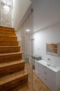 - un escalier dans une chambre avec des escaliers en bois et des murs blancs dans l'établissement House Franulich, à Stara Baška