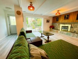 - un salon avec un canapé et une cheminée dans l'établissement The Rhodo Place, à Coquitlam