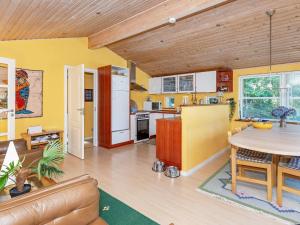 cocina con paredes amarillas y techo de madera en 6 person holiday home in L gst r, en Trend