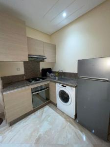 eine Küche mit einem Kühlschrank und einer Waschmaschine in der Unterkunft Les jardins de Bouznika in Bouznika