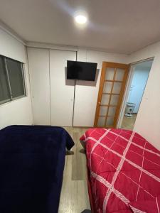 1 dormitorio con 1 cama y TV de pantalla plana en Hermoso Depto Terraza, en Rancagua