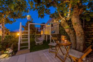 a deck with a tree and a table and chairs at Villa KaTess with heated pool in Split