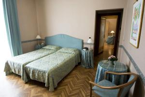 a bedroom with a bed and a glass table at Hotel Giglio in Montecatini Terme
