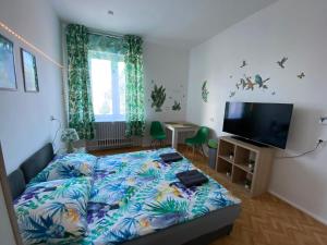 Un dormitorio con una cama y un televisor de pantalla plana. en Jungle Rooms, en Gdansk