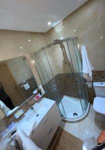 ein Bad mit einer Dusche, einem Waschbecken und einem WC in der Unterkunft Les jardins de Bouznika in Bouznika