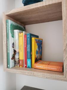 a row of books on a wooden shelf at SOLE MIO Vacation in San Vito lo Capo