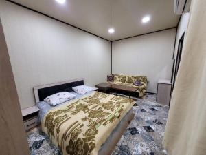 a bedroom with a bed and a chair in it at Дом с садом - Entire House with Garden in Tashkent