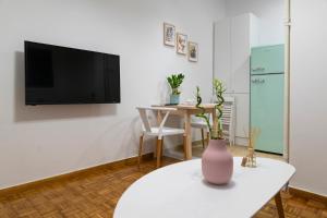 un soggiorno con tavolo e TV a parete di Lovely Apartment In Central Athens ad Atene