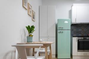 una cucina con tavolo e frigorifero blu di Lovely Apartment In Central Athens ad Atene